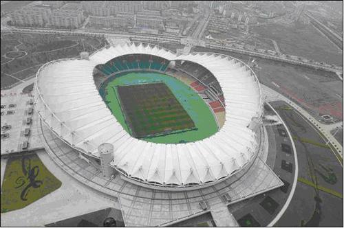 武汉体育中心体  育场是一座可容纳6万名观众的大型体育场,占地4.
