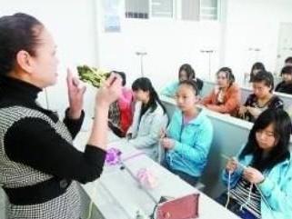 杨老师在向同学们传授织毛衣的技巧