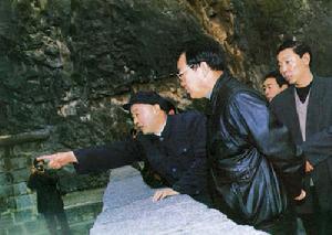 吴金印向李长春介绍当年拦河造田打山洞情景