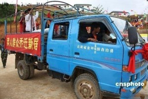图为莽人群众乘坐汽车喜迁新居